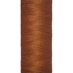 A spool of Gütermann thread in brown, displaying detailed thread texture. The label at the bottom shows "100 m - 110 yds/vgs." The cream-colored top and bottom caps highlight the thread's color.