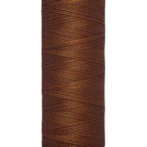 A spool of Gütermann thread, labeled as 100 meters or 110 yards. The thread is a rich brown color, neatly wound around the spool with beige ends.