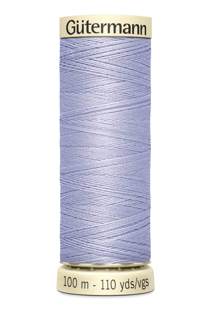 A spool of Gütermann sewing thread in light purple. The label indicates the length is 100 meters or 110 yards. The spool is cylindrical with beige ends, and the thread is neatly wound around it.