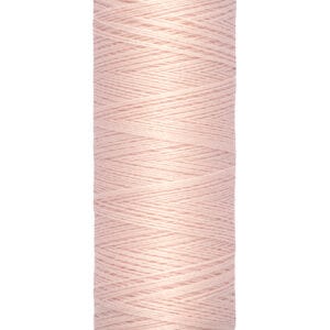A spool of Gütermann sewing thread, pale pink in color, with labels on the top and bottom. The bottom label reads "100 m - 110 yds/vgs.