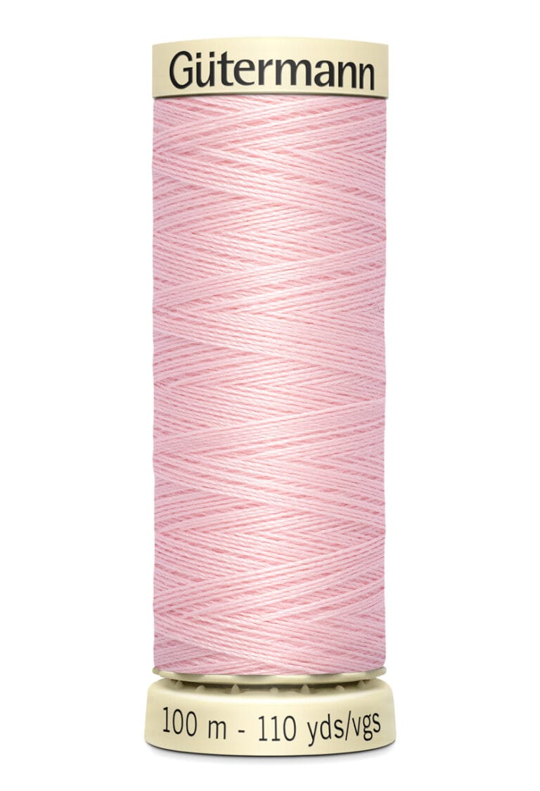 A spool of Gütermann sewing thread in light pink, featuring a cream-colored label. The label displays the brand name at the top and indicates 100 meters or 110 yards of thread at the bottom.