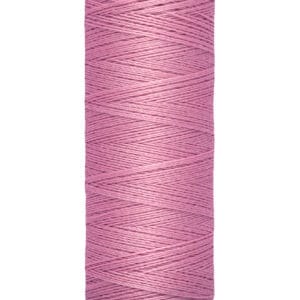 A spool of Gütermann thread in a pink color, with 100 meters (110 yards) of thread. The spool has a beige top and bottom with the brand name printed on the top and length details on the bottom.