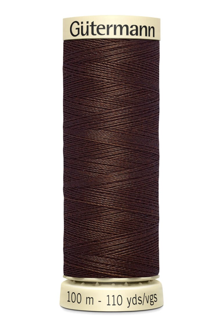 A spool of Gütermann thread in dark brown color, labeled with "100 m - 110 yds/vgs." The label is cream-colored with black text. The thread is neatly wound around the spool.