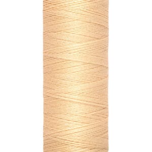 A spool of Gütermann thread in a light peach color. The spool label indicates 100 meters or 110 yards of thread.