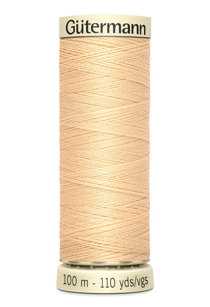 A spool of Gütermann thread in a light peach color. The spool label indicates 100 meters or 110 yards of thread.