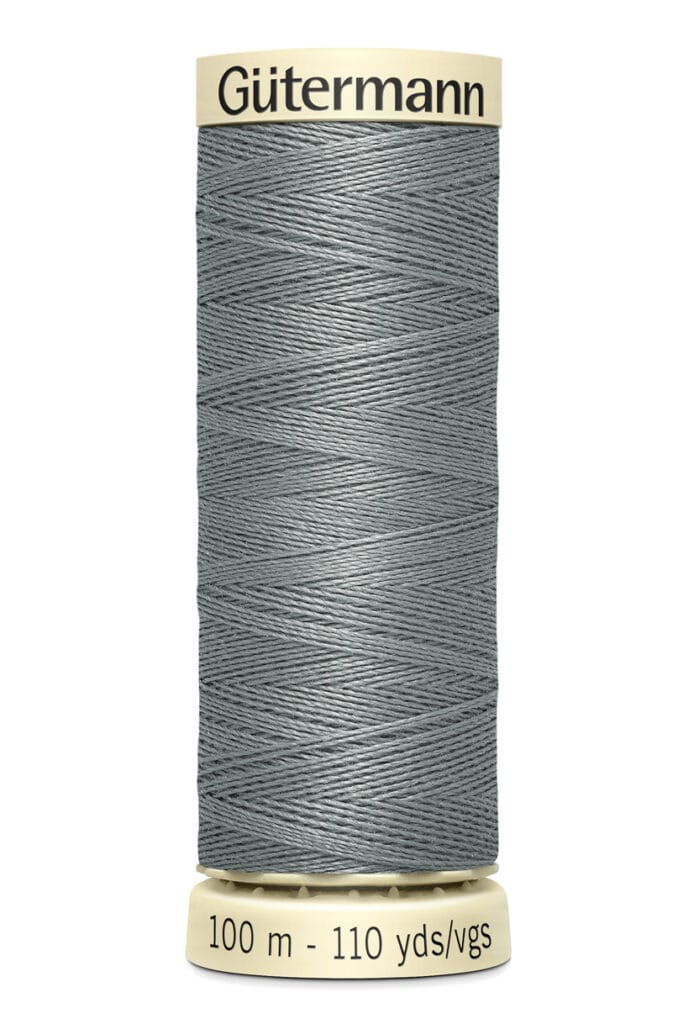 Spool of Gütermann sewing thread in a muted green color, labeled as 100 meters - 110 yards. The spool has beige caps at the top and bottom with the brand name printed on the top cap.