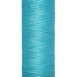 A spool of Gütermann sewing thread in bright turquoise. The label shows 100 meters and 110 yards. The spool is beige with the brand name at the top. The thread is neatly wound around the spool.