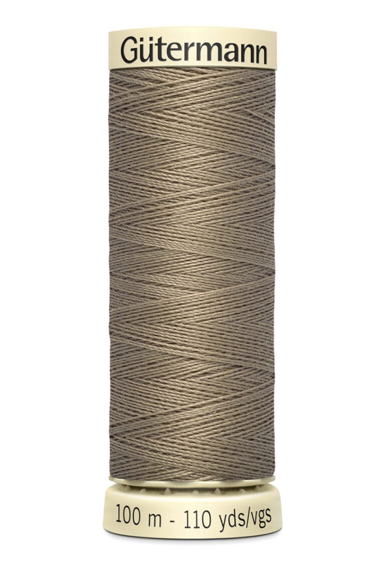 A spool of Gütermann thread in a beige color, labeled as 100 meters or 110 yards. The spool has a light yellow base and top, with the brand name printed on the top part.