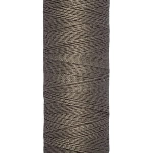 A spool of Gütermann thread in a dark gray color. The spool indicates the thread length of 100 meters or 110 yards. The top and bottom parts of the spool are a pale cream color, with the brand name displayed at the top.