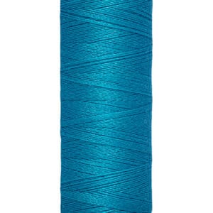 A spool of Gütermann sewing thread in vibrant teal is shown. The spool indicates it contains 100 meters or 110 yards of thread. The top and bottom of the spool are a cream color, contrasting with the blue thread.