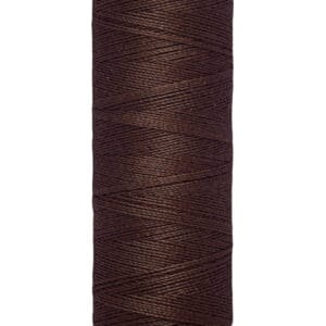 A spool of Gütermann brown sewing thread with a label indicating 100 meters or 110 yards. The thread is neatly wound, and the label is cream-colored with black text.
