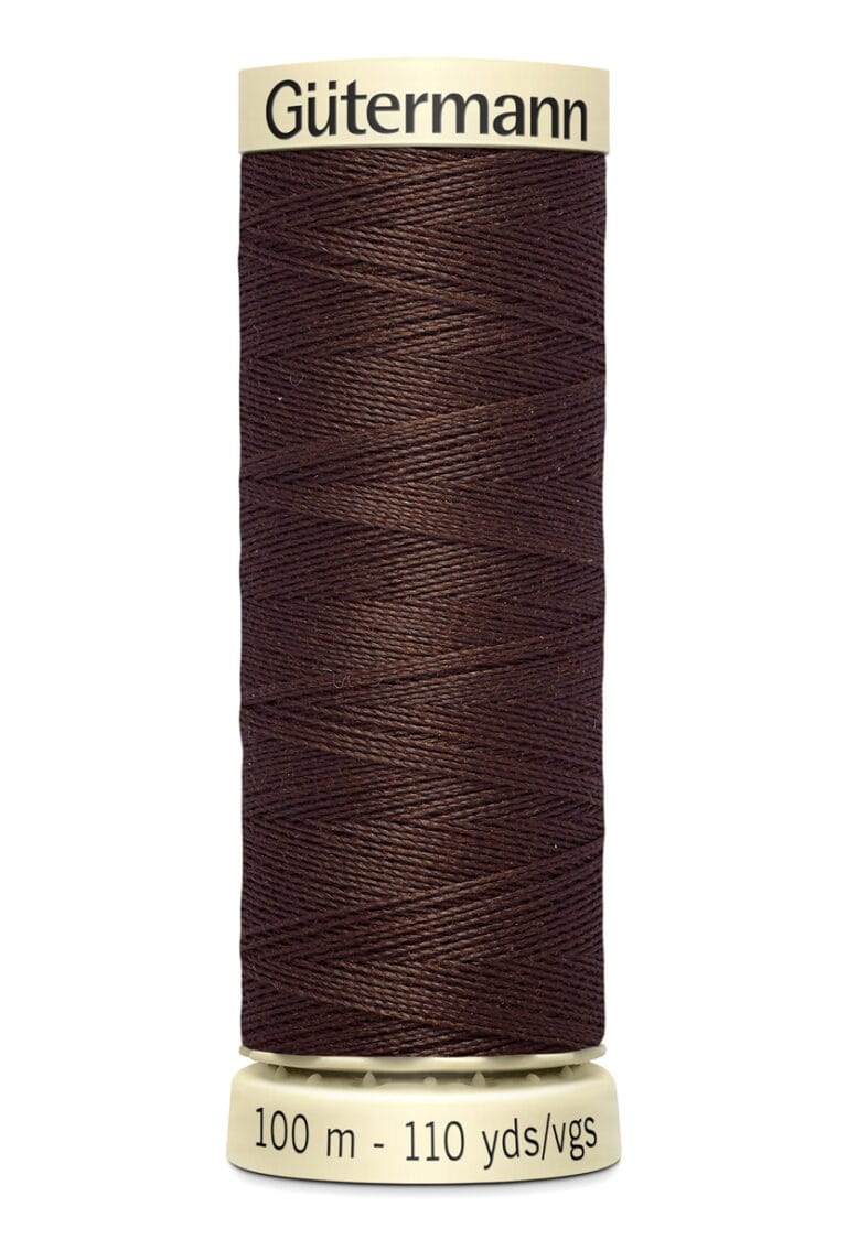 A spool of Gütermann brown sewing thread with a label indicating 100 meters or 110 yards. The thread is neatly wound, and the label is cream-colored with black text.