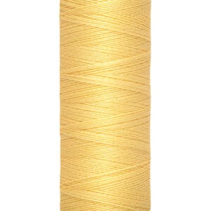 A spool of Gütermann light yellow sewing thread. The label indicates 100 meters or 110 yards.