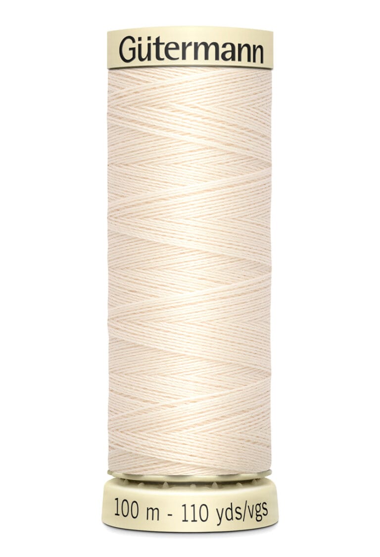 A spool of Gütermann sewing thread in cream color is centered in the image. The label reads "Gütermann" at the top and "100 m - 110 yds/vgs" at the bottom. The spool has a beige base.