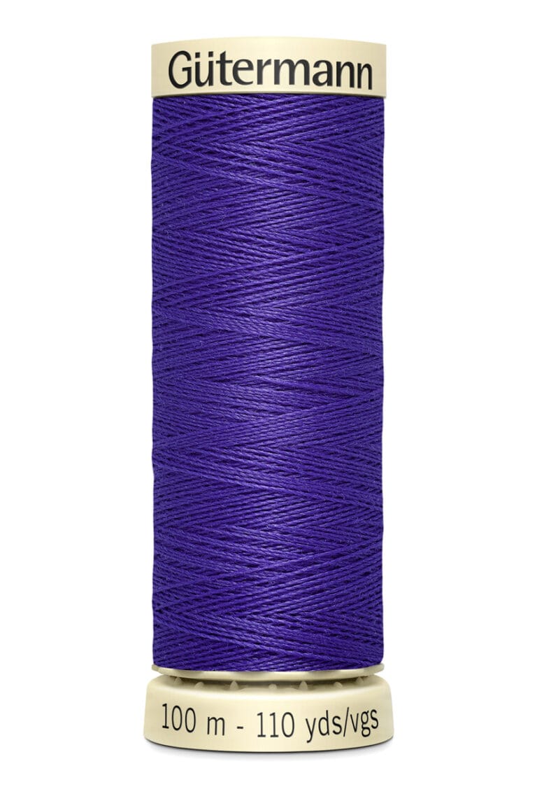 A spool of Gütermann thread with a deep purple color. It is marked with "100 m - 110 yds" on the bottom. The thread is neatly wound around a beige spool.