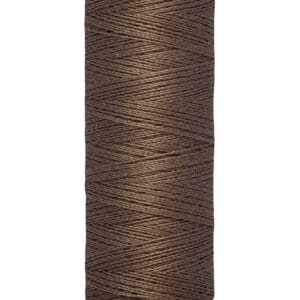 A spool of Gütermann thread in a brown color is shown. The label indicates 100 meters and 110 yards. The spool has cream-colored ends with the brand name in black text on the top.