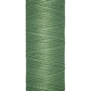 A spool of Gütermann sewing thread in a muted green color is shown. The spool is vertically oriented, with a label indicating it contains 100 meters (110 yards) of thread.