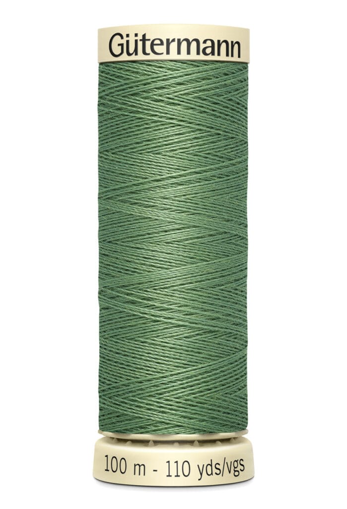 A spool of Gütermann sewing thread in a muted green color is shown. The spool is vertically oriented, with a label indicating it contains 100 meters (110 yards) of thread.