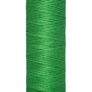 A spool of Gütermann green sewing thread is vertically oriented. The label on top shows the brand name, and the base indicates 100 meters or 110 yards of thread. The thread is tightly wound around the spool.