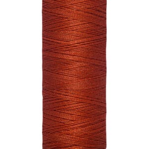 A spool of Gütermann thread in a rich reddish-brown color. The spool label reads "Gütermann" at the top and at the bottom, "100 m - 110 yds/vgs." The thread is neatly wound on a beige plastic spool.