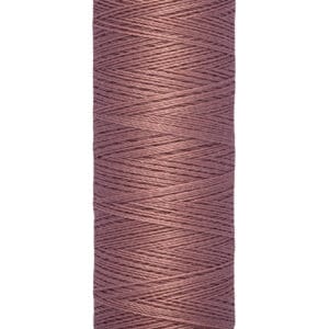 Spool of Gütermann thread in a dusty rose color, displayed vertically. The label states 100 meters or 110 yards. The thread is wound neatly around the spool, which has a light beige color with product branding at the top.