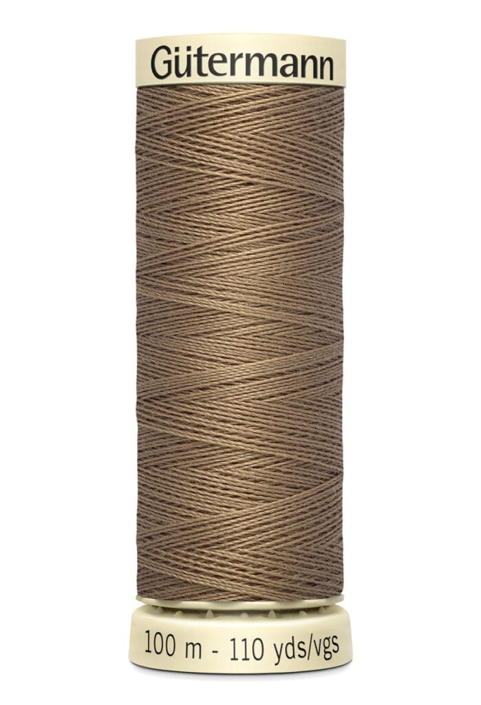 A spool of brown Gütermann sewing thread, labeled for 100 meters and 110 yards, with a beige base and top.