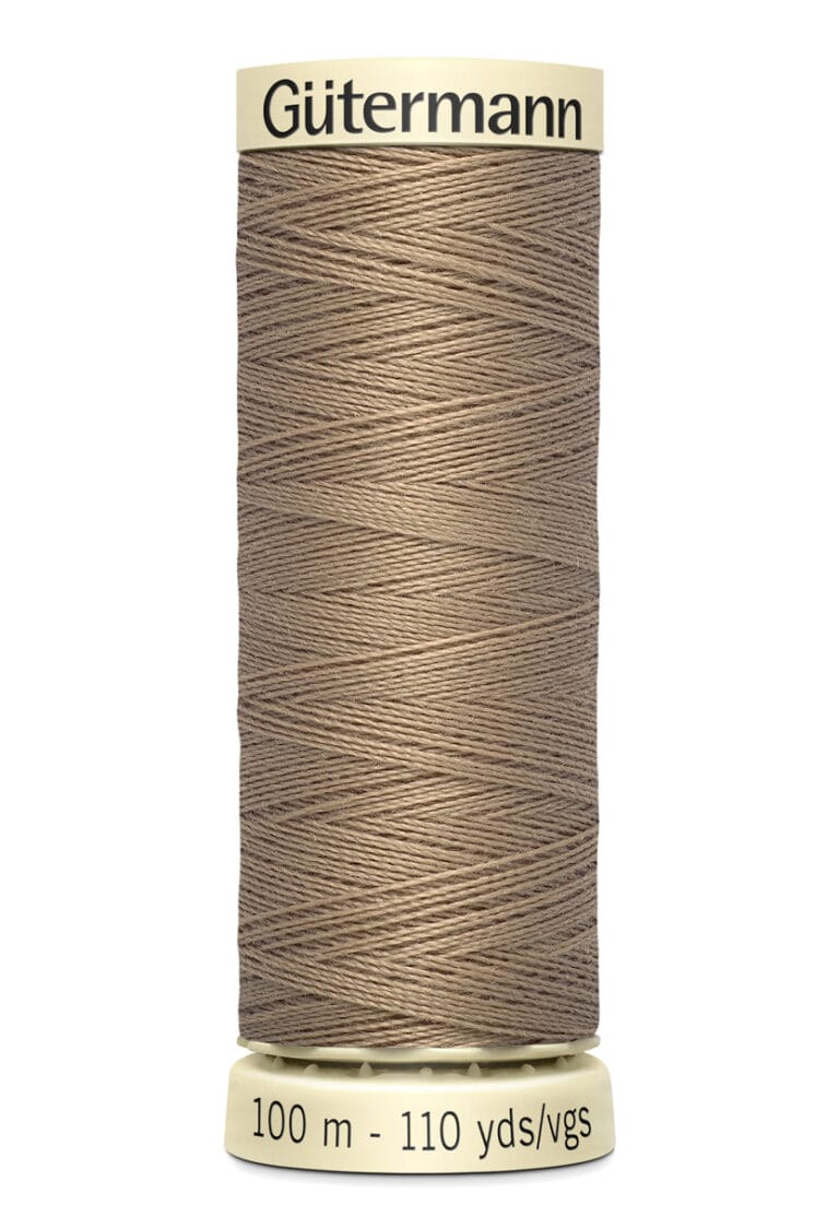 A spool of Gütermann brown sewing thread. The label reads "100 m - 110 yds/vgs." The spool has a cream-colored top and bottom with the brand name printed in black on the top.