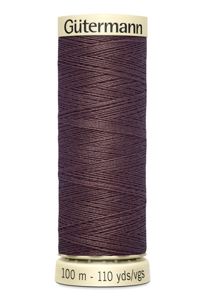A spool of Gütermann sewing thread with a dark brown color. The spool is labeled with "100 m - 110 yds/vgs" indicating the thread's length.