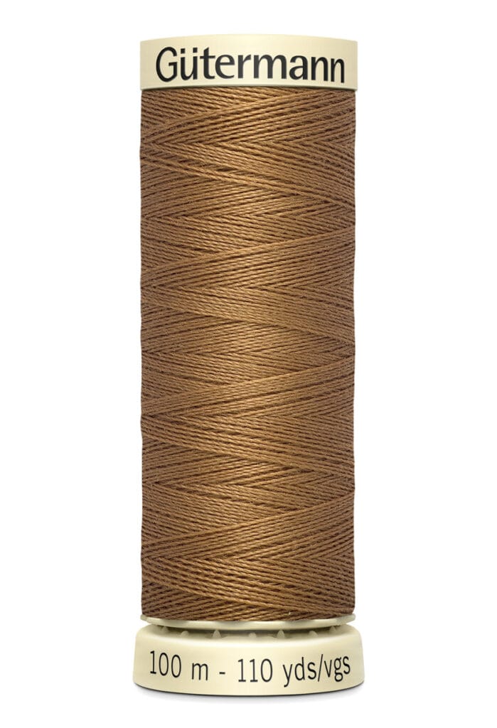 A spool of Gütermann brown sewing thread, labeled with measurements of 100 meters and 110 yards. The spool has a cream-colored base and top with the brand name printed on it.
