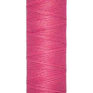 A spool of pink Gütermann sewing thread, labeled with "Gütermann" on the top and "100 m - 110 yds/vgs" on the bottom. The thread is tightly wound around a beige cylindrical spool.