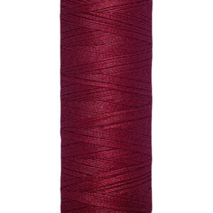 A spool of Gütermann thread with deep red color, wrapped neatly around a beige spool. The label on the bottom reads "100 m - 110 yds/vgs.