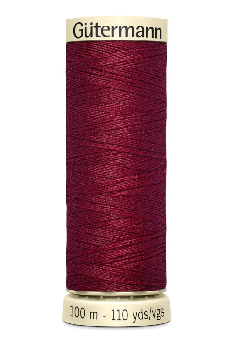 A spool of Gütermann thread with deep red color, wrapped neatly around a beige spool. The label on the bottom reads "100 m - 110 yds/vgs.