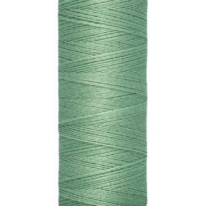 A spool of Gütermann sewing thread in a teal color. The spool shows "100 m - 110 yds/vgs" indicating the length of the thread. It has a beige top and bottom.