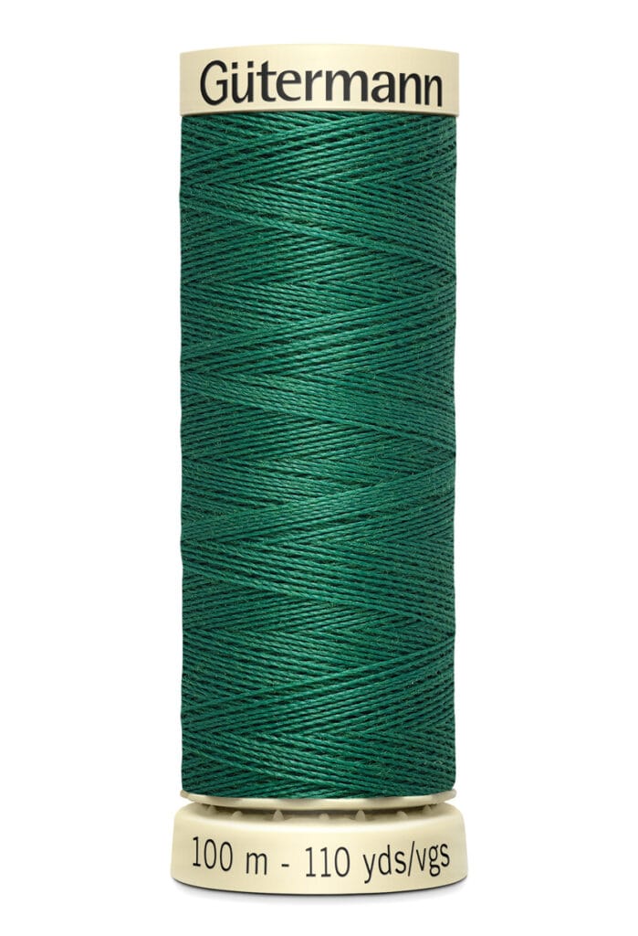 A spool of Gütermann sewing thread in deep green, wound around a beige cylindrical holder. The label reads "Gütermann" at the top and "100 m - 110 yds/vgs" at the bottom.