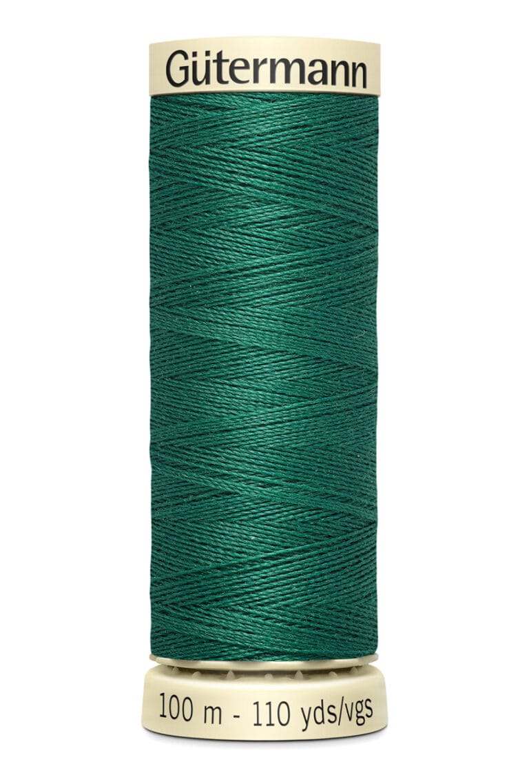 A spool of Gütermann sewing thread in emerald green. The spool is beige with black text that reads "Gütermann" on the top and "100 m - 110 yds/vgs" on the bottom. The thread is neatly wound around the spool.