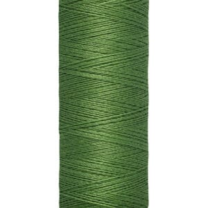 A spool of Gütermann green sewing thread labeled with "100 m - 110 yds/vgs".