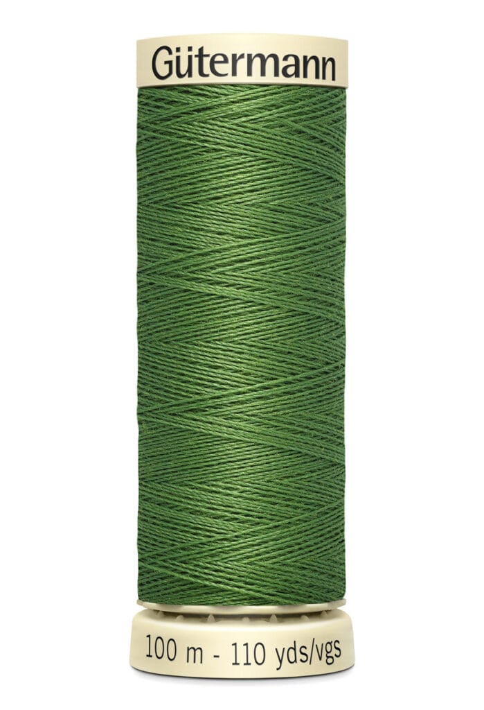 A spool of Gütermann green sewing thread labeled with "100 m - 110 yds/vgs".