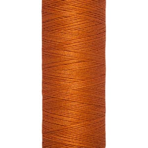 A spool of Gütermann thread in a warm orange hue, labeled on the base with "100 m - 110 yds/vgs.