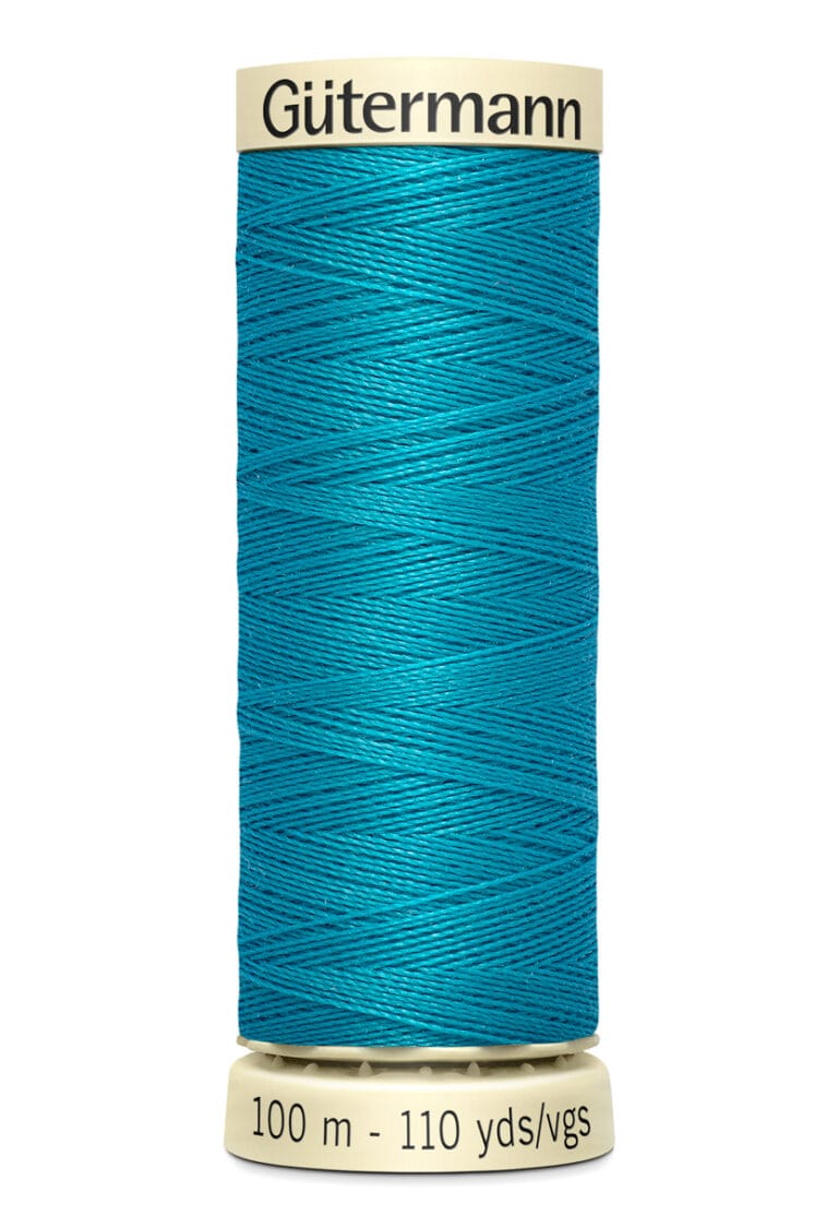 Spool of Gütermann thread in teal blue, labeled "100 m - 110 yds/vgs." The spool is beige, with the brand name "Gütermann" at the top.