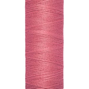 A spool of Gütermann thread in dusty pink, labeled 100 meters and 110 yards, with cream-colored ends.