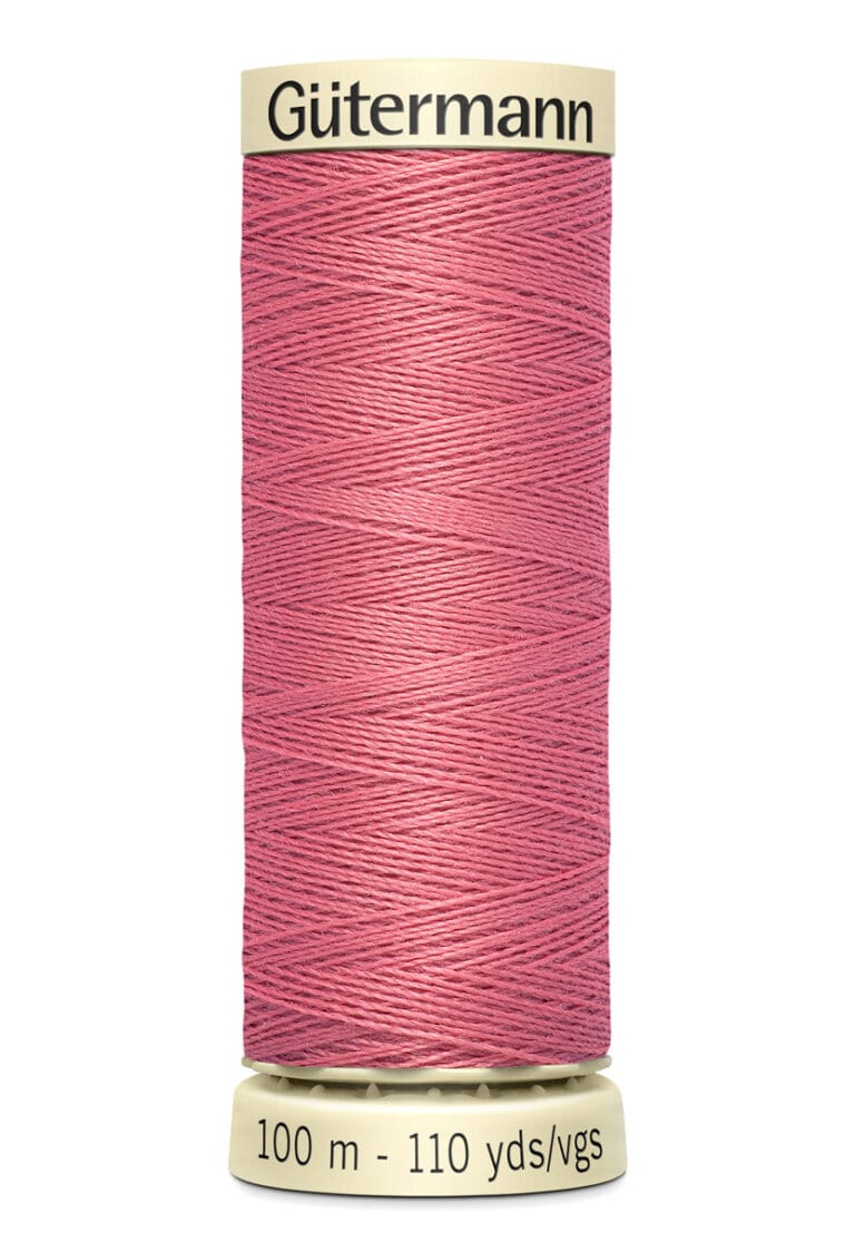 A spool of Gütermann thread in dusty pink, labeled 100 meters and 110 yards, with cream-colored ends.