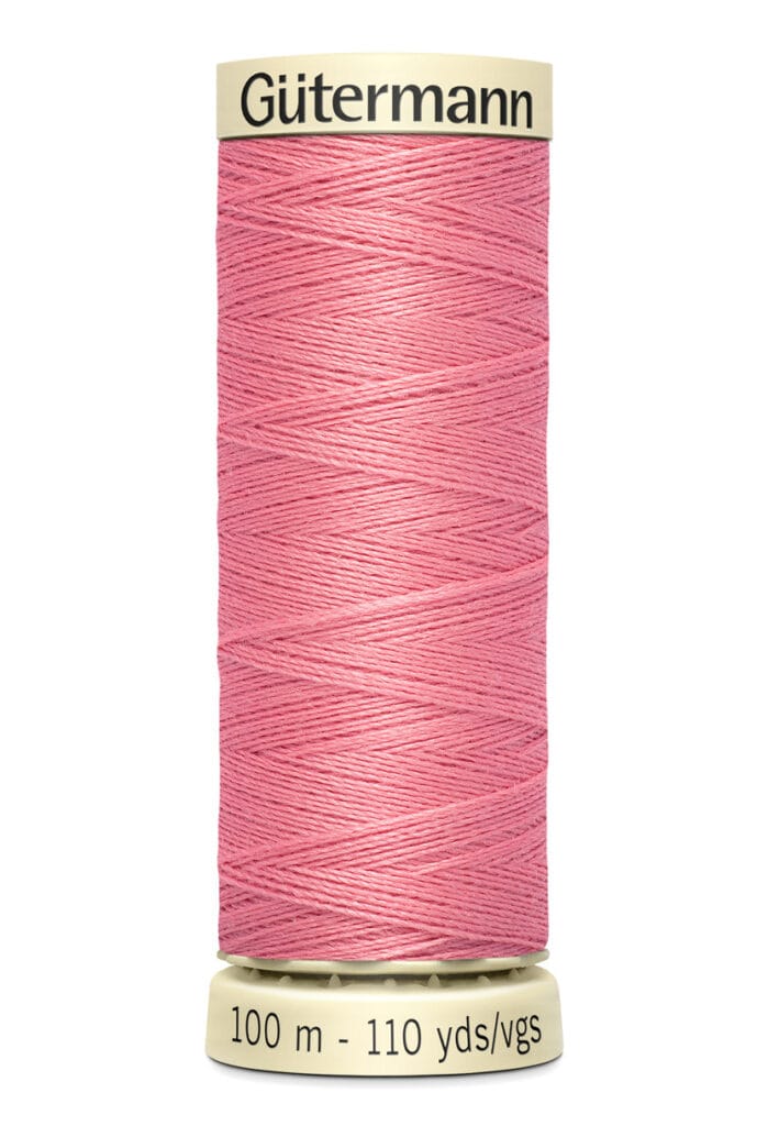 A spool of Gütermann thread, featuring a light pink color. The spool is labeled with measurements "100 m" and "110 yds/vgs" on a beige base, with the brand name at the top.