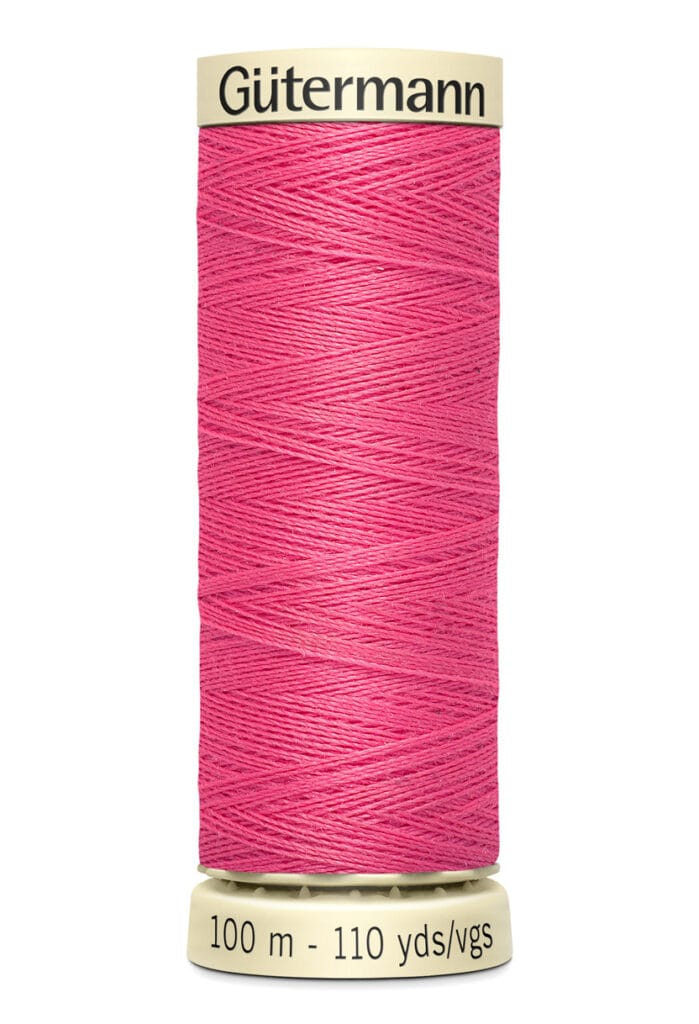 Spool of Gütermann pink sewing thread, labeled 100 meters, 110 yards.
