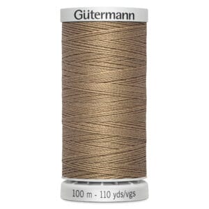 A spool of Gütermann thread, 100 meters (110 yards), in a beige color. The thread is neatly wound around a cylindrical white plastic spool.