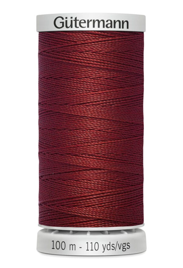 A spool of Gütermann thread with a rich burgundy color. The label indicates a length of 100 meters or 110 yards. The thread is neatly wound on a white spool.