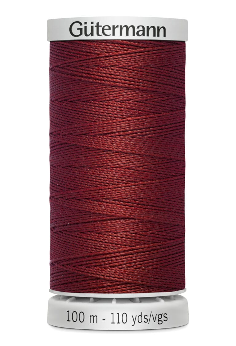 A spool of Gütermann thread with a rich burgundy color. The label indicates a length of 100 meters or 110 yards. The thread is neatly wound on a white spool.