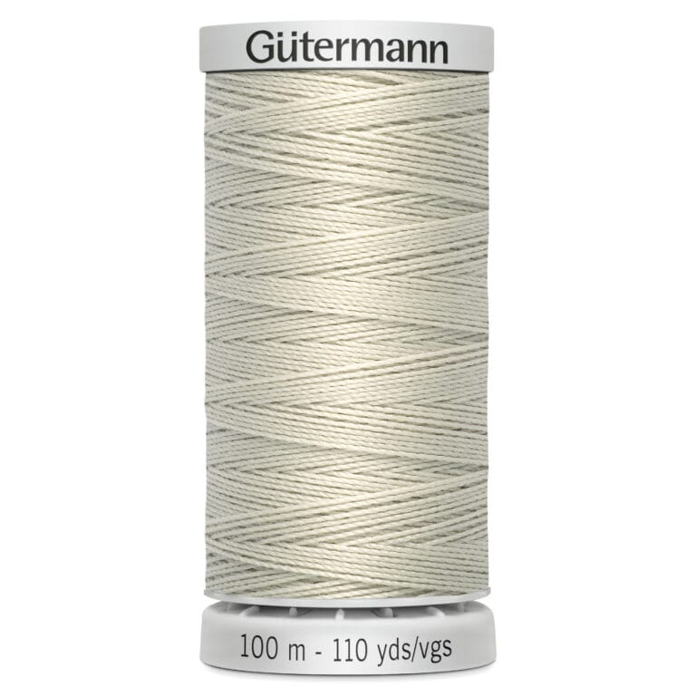 A cream-colored spool of Gütermann thread is displayed upright. The label on the spool indicates it's 100 meters or 110 yards long. The thread is tightly wound, showcasing its smooth texture.