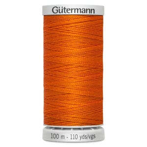 A spool of Gütermann thread in bright orange. The spool displays the brand name on top and indicates 100 meters or 110 yards at the bottom. The thread is neatly wound around the cylindrical spool.