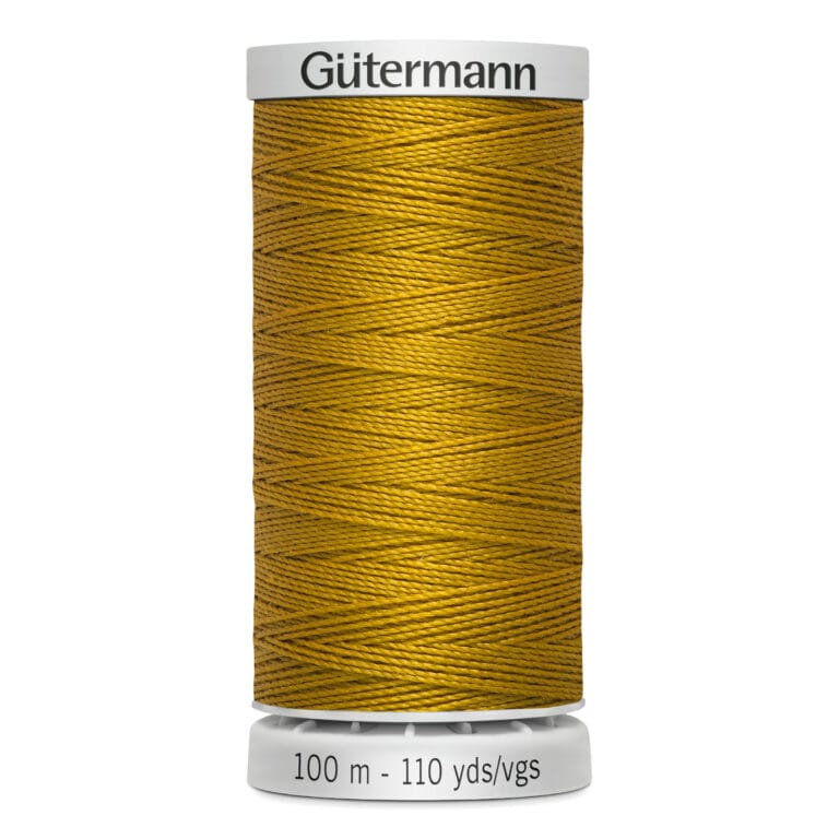A spool of Gütermann thread in gold color. The spool is labeled with "100 m - 110 yds/vgs" and features a white base and top. The thread is neatly wound around the spool, showcasing its vibrant hue.