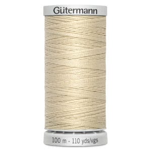 A spool of Gutermann thread, cream colored, with a label indicating 100 meters or 110 yards. The spool is cylindrical with thread wound neatly, set against a plain white background.